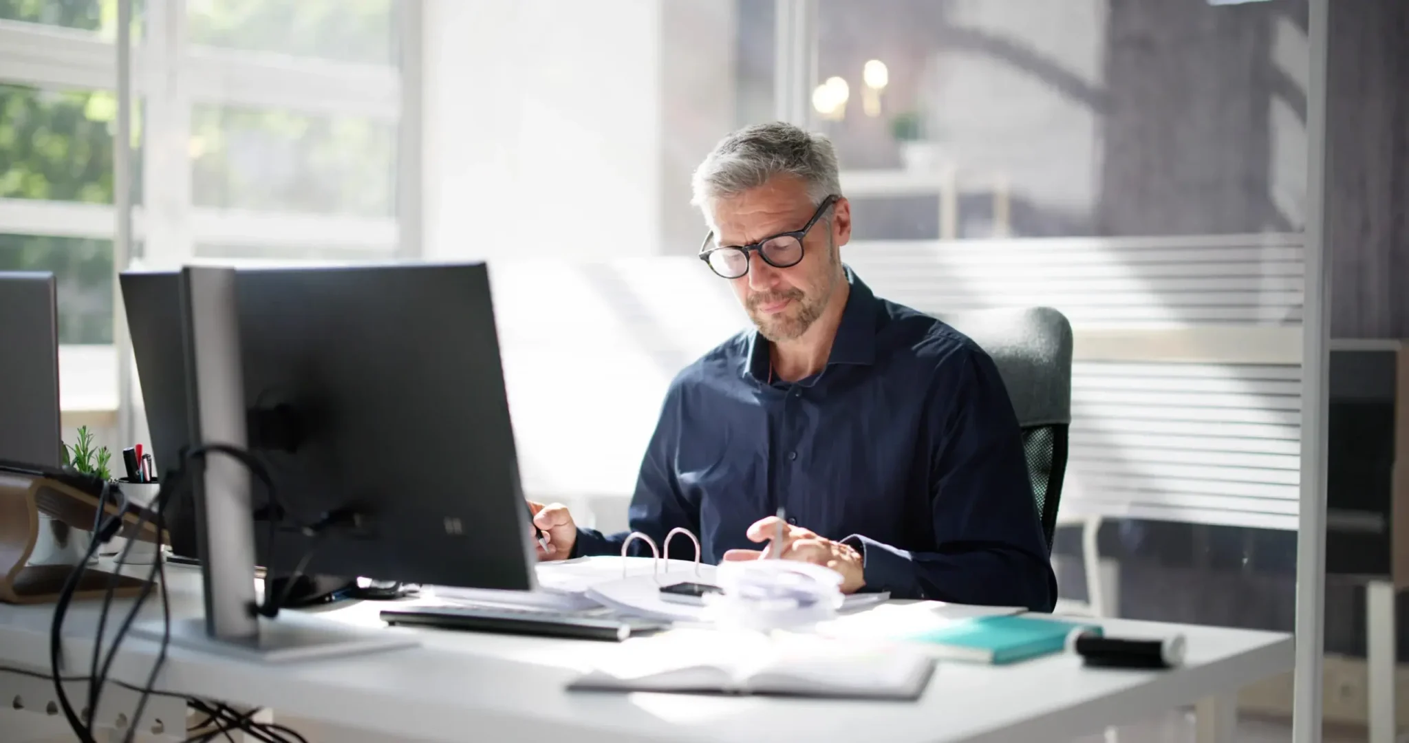 Professional reviewing financial documents at a desk, illustrating the advantages of cloud-based accounting software for efficient business finance management