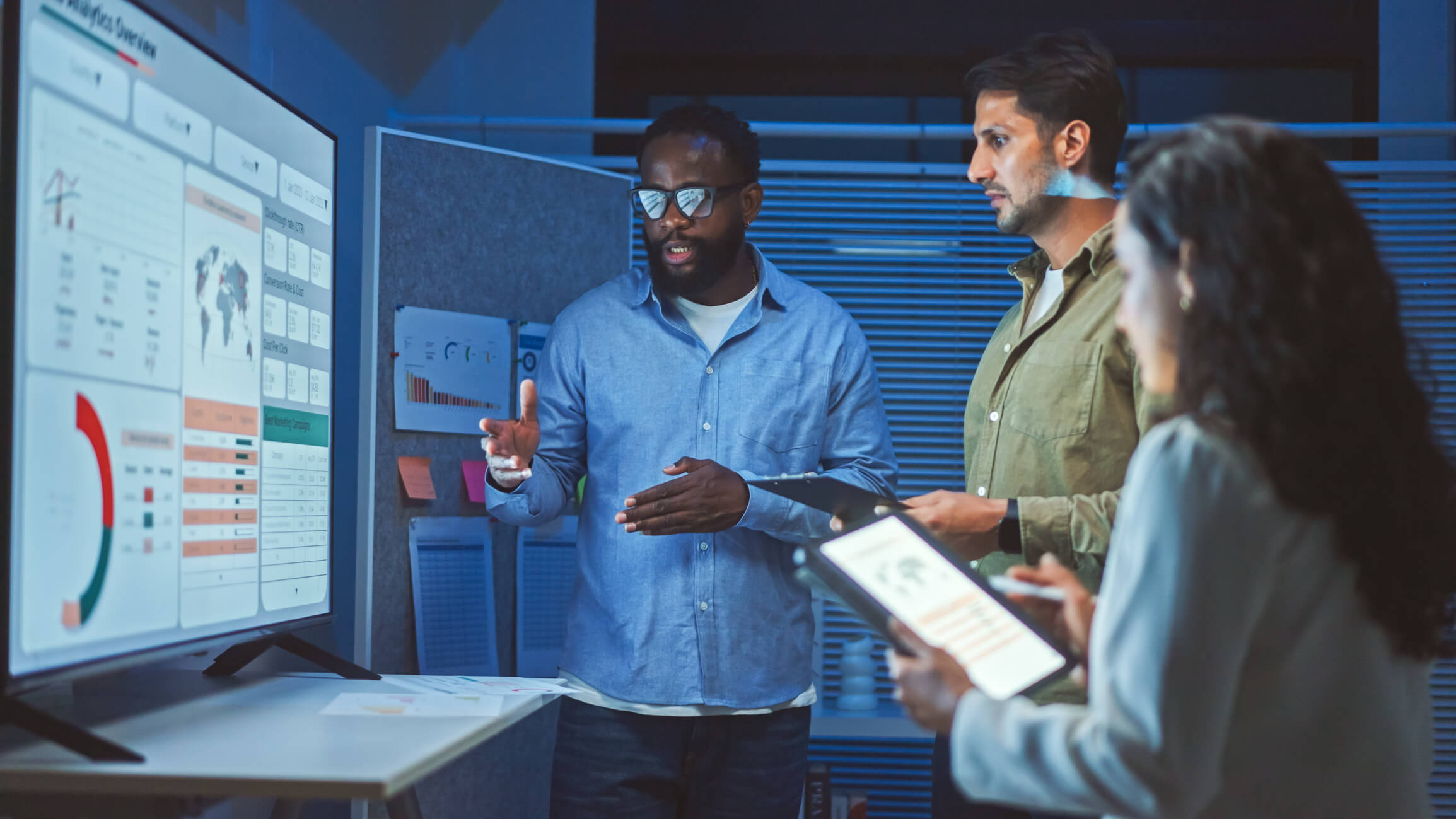 Accounting team reviewing data on multiple screens in modern office